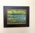 This oil painting captures a serene waterscape, where lush greenery frames a tranquil pond dotted with lily pads. The...