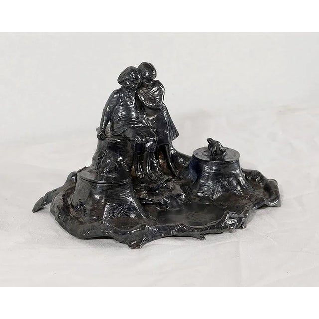 Beautiful pewter inkwell monogrammed depicting two young children each looking at a frog placed on an inkwell. The...