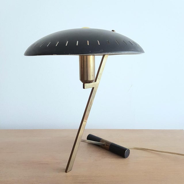 Viewed from the side, the eponymous Z shape emerges. The perforated lampshade is fixed to a diagonally positioned narrow...