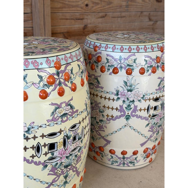 A beautifully decorated pair of Chinese export porcelain garden stools featuring a warm ivory ground with intricate...