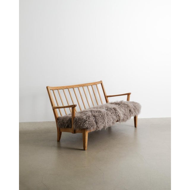 A rare swedish modern wooden two seater sofa model "stugan" in stained pine and newly upholstered long haired taupe...