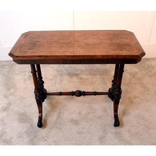 A handsome victorian walnut writing table dating to around 1880. The rectangular top with chamfered corners and moulded...