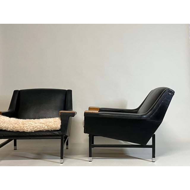 Pair of Scandinavian lounge chairs from the 1970s, upholstered in leatherette. The chairs have generous proportions and a...