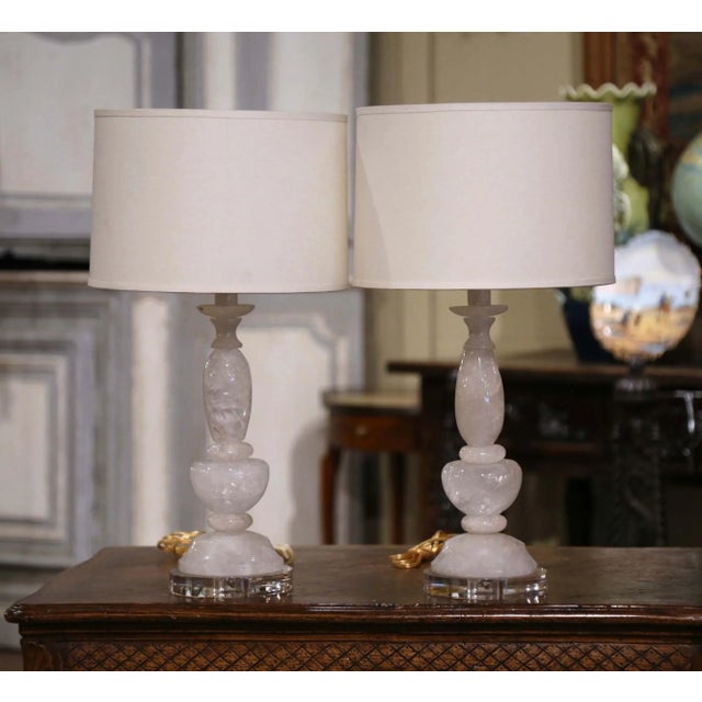 Bring luminous elegance to a living room, bedroom, den, or formal sitting area with this sophisticated pair of carved rock...
