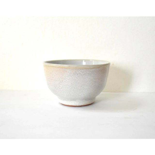A studio or art pottery bowl, with a subtle pale blue glaze on the interior and white glaze outside. 4"x2.5".