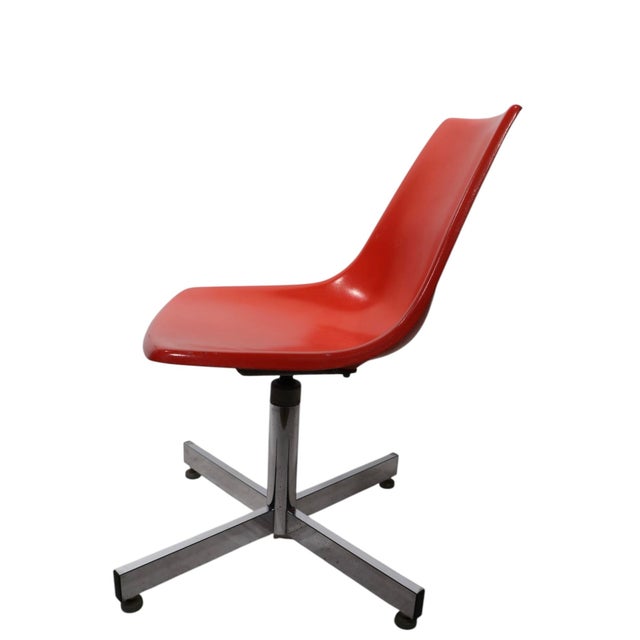 Classic Mid Century swivel desk chair, executed in orange fiberglass, and bright chrome. The seat swivels a full 360...