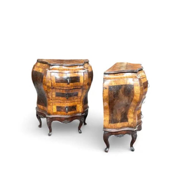 A Pair of 19th Century Italian Rococo-Style Bombé Chests, beautifully crafted in burled walnut veneer. The warm honey and...