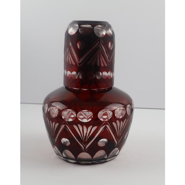 Striking and richly colored, this vintage Bohemian bedside carafe set features deep ruby flashed glass with crisp wheel-...
