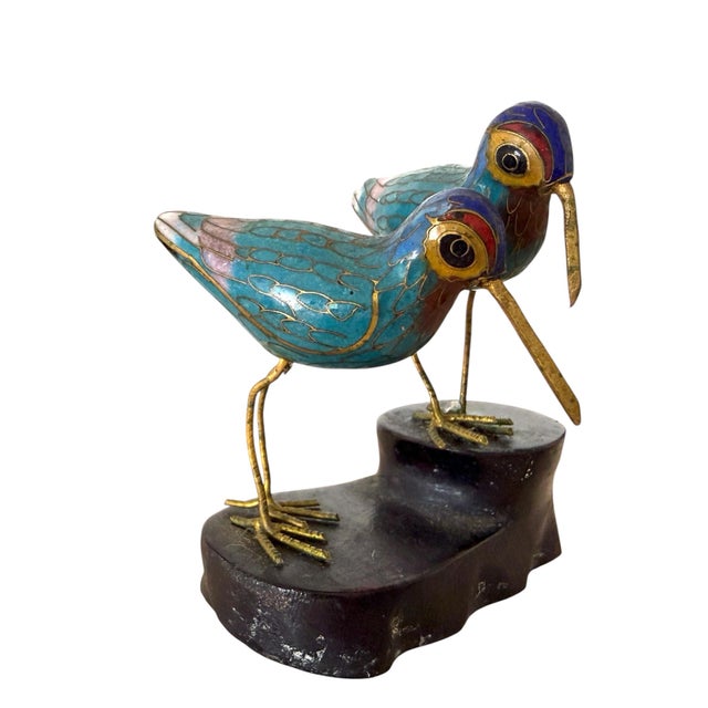 Two cloisonné enameled birds on a carved wood base. Yves Klein blue heads and turquoise and pink feathers on their bodies.