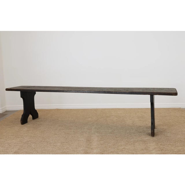 Dimensions: 14.5"D x 84"L x 19"H A beautiful antique oak bench with a rich, darkened patina and sculptural cut-out legs—an...