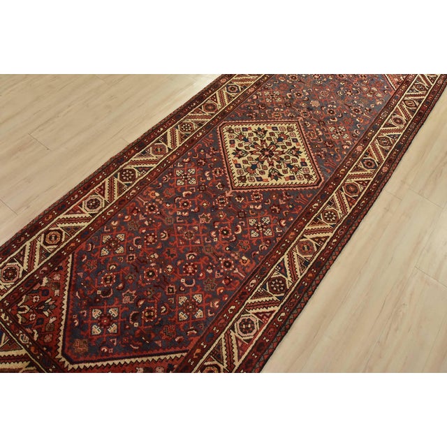 An authentic vintage tribal Hamedan runner hand-knotted with fine wool and natural dyes. This nomadic rug features a...