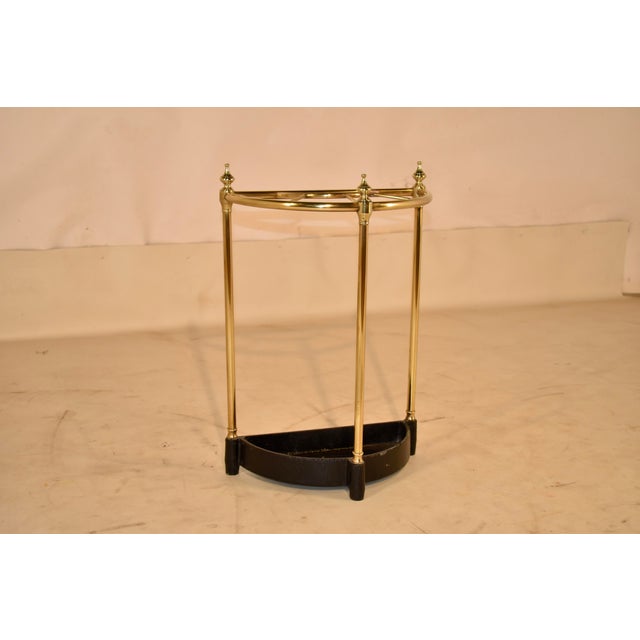 Circa 1950's cast brass and iron umbrella or cane stand from England. The stand is in a demilune shape, which is nice for...