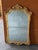 An elegant French Louis XV style giltwood wall mirror, beautifully hand carved and retaining its original beveled mirror...