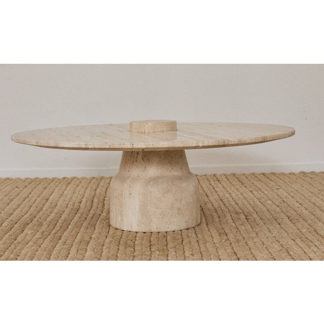Round travertine coffee table, 1970s. The travertine is honed / matte and has a ton of texture. The pedestal base has a...