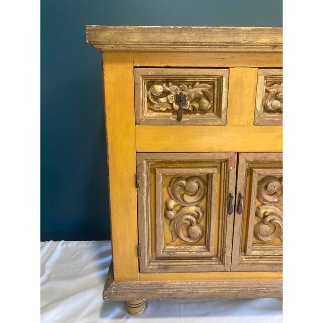 Truly unique rustic European antique cabinet painted mustard yellow with gold trim. Beautiful antique drop pulls.