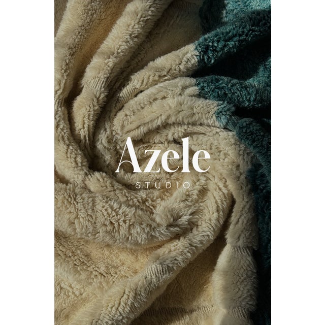 Deep red, ivory, and teal sweep across this rug in bold diagonal bands, echoing the layered horizon of a coastal...