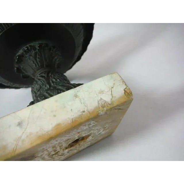 Antique 19th c. Grand Tour bronze urn mounted on a white marble base. The urn with relief acanthus leaf decoration and...