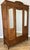 A stunning Antique French wardrobe crafted in oak with elegant mirrored doors and beautifully carved decorative detailing...