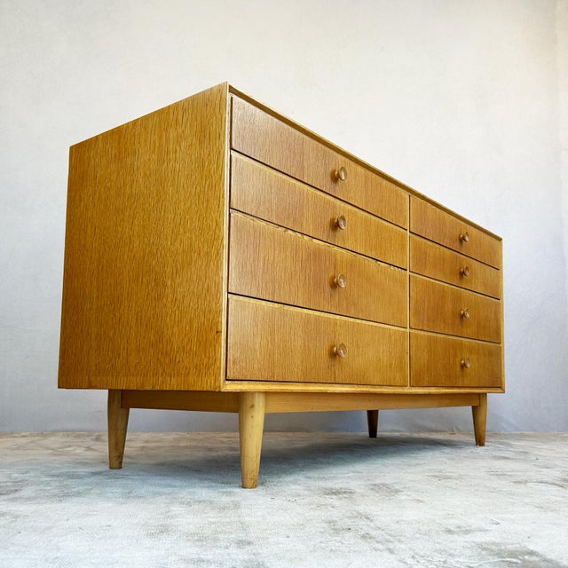 Constructed with oak-veneered panels throughout on a frame carcass. The piece features eight drawers arranged in two...