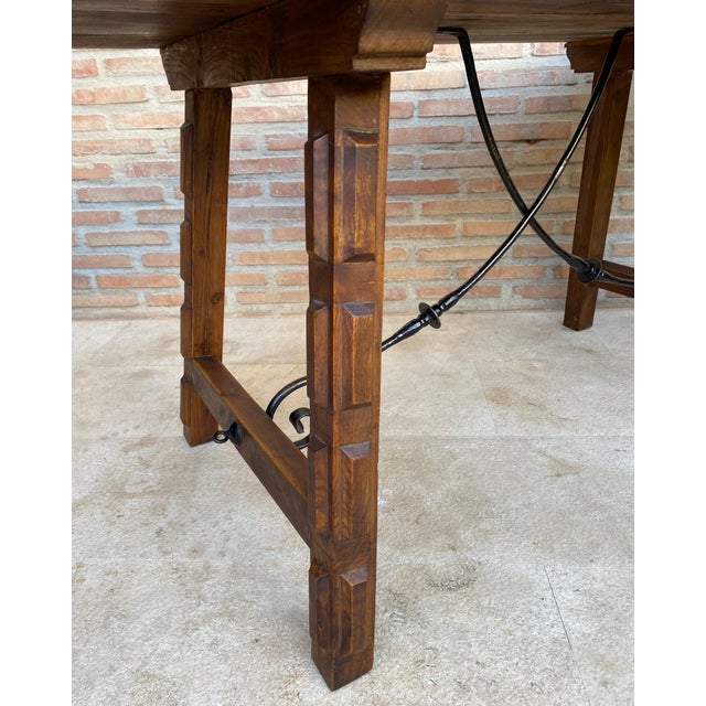 Walnut side table with carved legs and level top. Spanish, the legs are joined by an original iron frame, from the 19th...