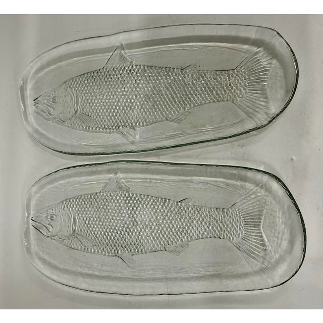 Pair of 1970s vintage clear glass fish platters designed by Ann and Gorman Warf for Kosta Boda, Sweden. Each is unique, so...