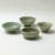 A set of four Japanese-style ceramic bowls, each varying in shape and size; the glaze features a vein-like pattern, with a...