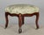 A pair of French Louis Philippe style upholstered foot stools with carved mahogany frames. One with wooded castors and one...