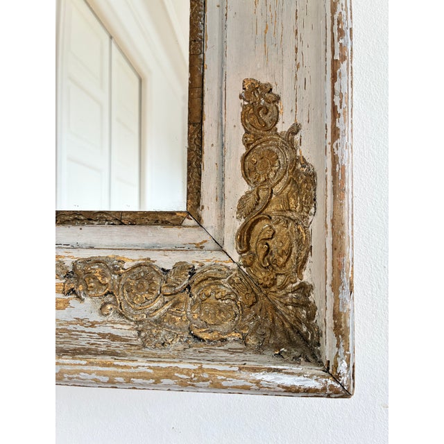 An antique French Napoleon III-style wall mirror, dating to the late 19th century. The mirror has a wide wooden frame with...