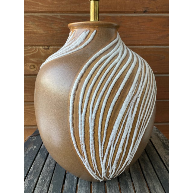 Sizable Mid-Century Modern lava glazed drip pottery table lamp. Matte brown tone ceramic glazed bases feature a white...