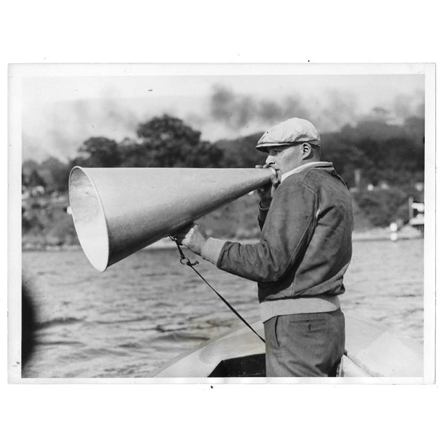 Black and white photo of Charles Whiteside of Harvard University coaching his rowers on the Thames River in Red Top,...