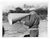 Black and white photo of Charles Whiteside of Harvard University coaching his rowers on the Thames River in Red Top,...