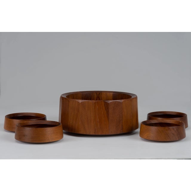 A vintage Mid-Century JensQuistgaard for Dansk Danish Teak faceted salad or serving bowl with four unmarked serving bowls....