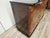 An elegant 1950s Italian Art Deco sideboard, featuring a refined burl veneer and elegant black lacquered wood details that...