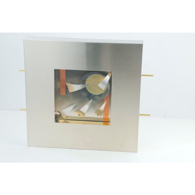 Striking vintage modern wall sculpture featuring a brushed stainless steel frame with an abstract dimensional composition....
