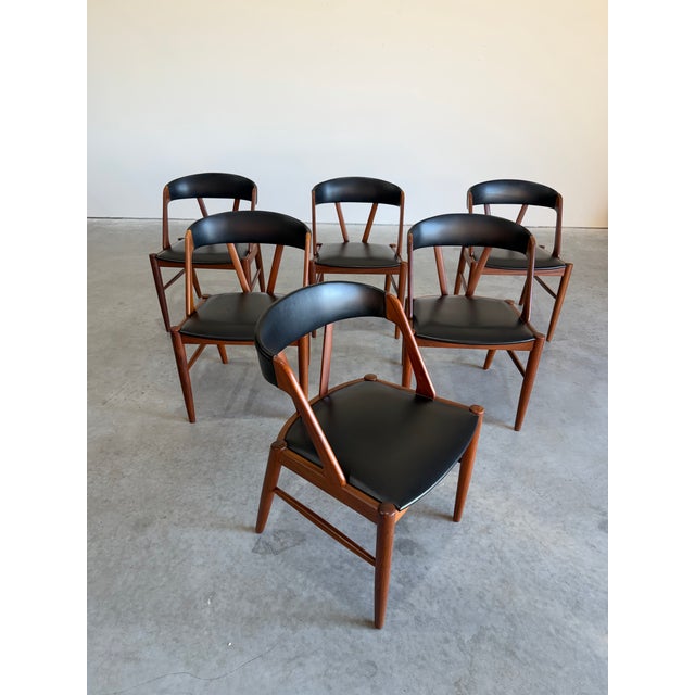 Set of 6 Danish Teak and black vinyl dining chairs, a nod to Kai Kristiansen’s model 31’s, but distinctly their own with...