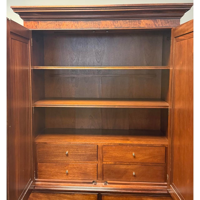 Elegant Ethan Allen Newport Collection armoire featuring a rich reddish-brown wood finish and striking, beautifully...