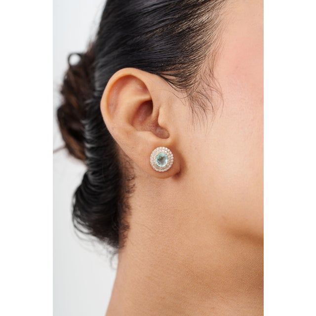 Make a statement with these elegant Paraiba tourmaline double halo stud earrings, beautifully crafted in 14K solid yellow...