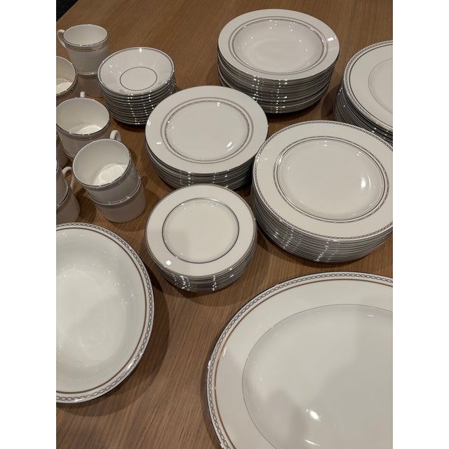 12 full settings of 7 pieces each, plus 2 extra dinner plates, a sugar bowl and lid and creamer, an oval vegetable bowl...
