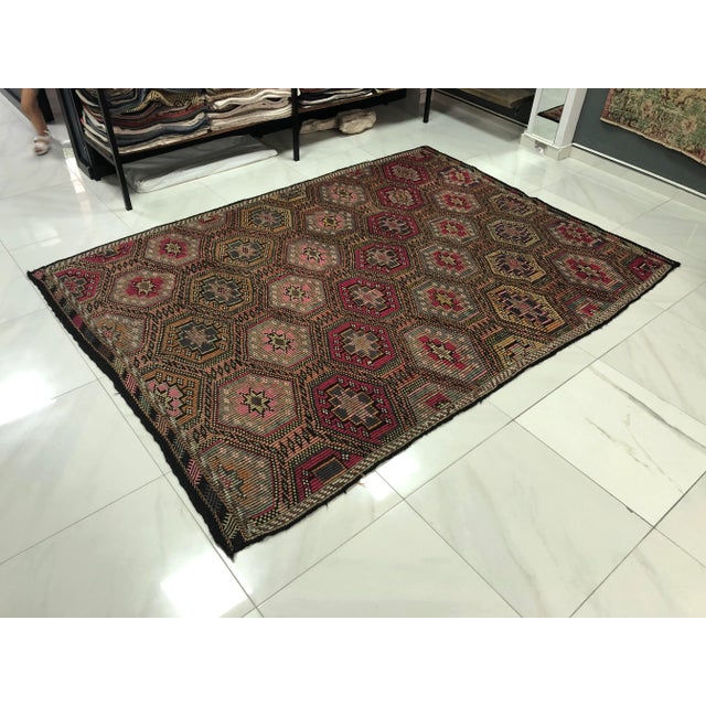 This is a vintage Turkish Anatolian kilim rug from the 1960s. The piece was hand-woven.