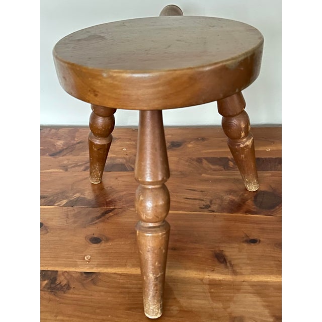 Vintage wood milking stool with three turned legs and a handle for carrying. Made in Japan. Top is 10” across. Height is...