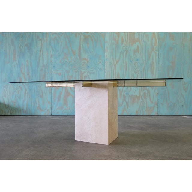 A travertine and brass dining table attributed to Artedi circa 1980s. A minimalist postmodern feel combining natural...