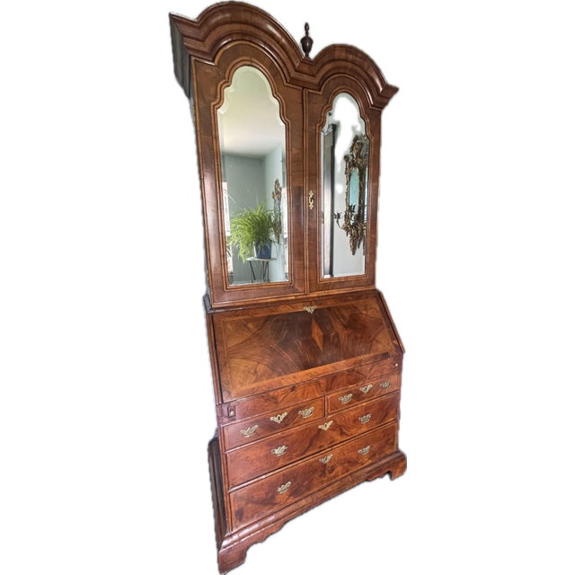 An 18th-century English walnut bureau bookcase with a double-domed bonnet top. The figured walnut veneers have a deep,...