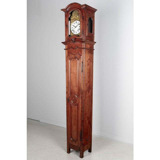 A French Horloge De Parquet, or tall case clock made of solid cherry. The case is from the 18th century and the clock is...