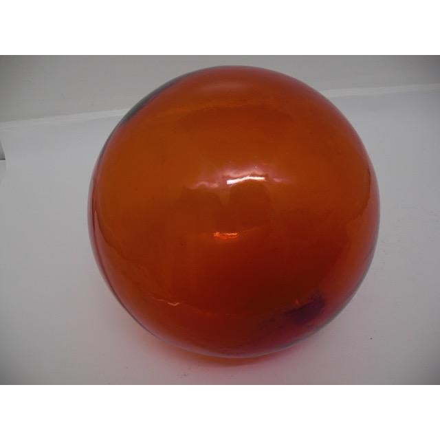 Vintage, handblown red glass Japanese fishing float. Its rich red hue and subtle surface variations speak to decades of...