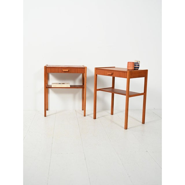 Pair of vintage Scandinavian teak nightstands with a drawer, a magazine rack, and wooden details with a soft, distinctive...