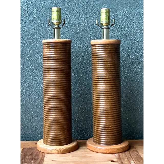 This vintage pair of pencil reed cylinder lamps combines the warmth of natural wood with the quiet gleam of brass in a...