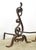 Antique Arts & Crafts style andirons made of wrought iron with a loose ring on the top attached to a curled design....