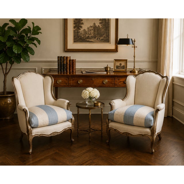 Timeless and inviting, this pair of Louis XV–style wingback bergère chairs features beautifully carved giltwood frames and...