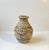 Italian earthenware vase decorated in relief with putti's and floral ornamentation. Hues of gold and blue/green glaze...