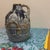 Features a cobalt blue glaze with gold and white embossed detailing of a European cathedral or city scene, often...